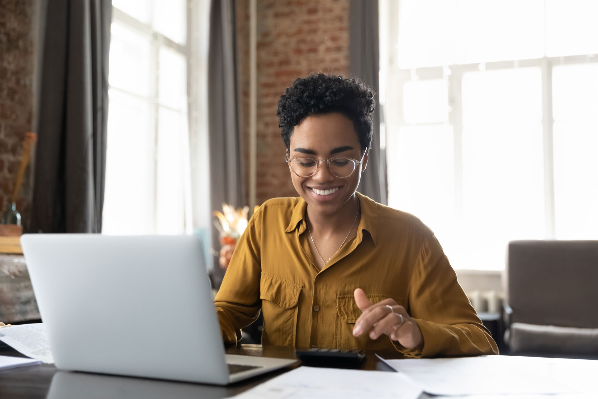 Young African American lady looking at paperwork and doing math